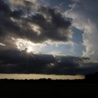 The sun breaks through the clouds, casting a dramatic light over the landscape.