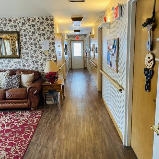 A cozy hallway with floral wallpaper, a comfortable couch, and warm decor.