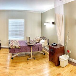 A clean and organized hospital room with a bed and medical equipment.