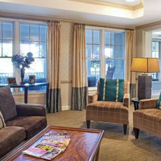 A cozy and elegant living room with comfortable seating and natural light streaming through large windows.