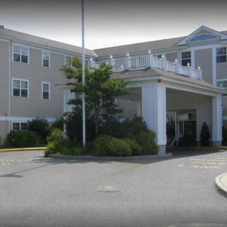 A hotel entrance with landscaping and a covered driveway.
