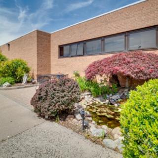 A brick building with well-maintained landscaping and a small garden.