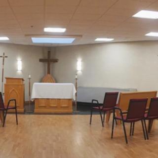 A small chapel with an altar and chairs arranged for a service.
