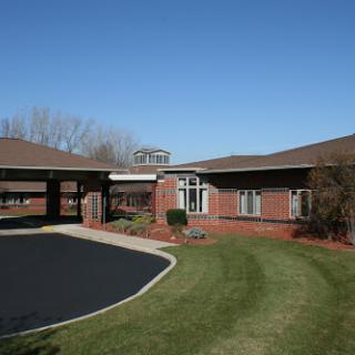 A modern brick building with a well-maintained lawn and clear blue sky.