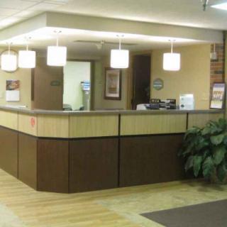 Modern reception area with a wooden desk and pendant lighting.