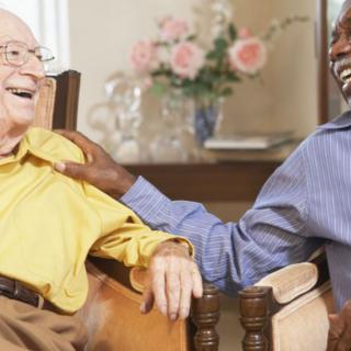 Two elderly men enjoying a laugh together indoors.
