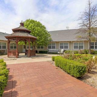 A peaceful courtyard featuring a wooden gazebo surrounded by well-maintained landscaping.