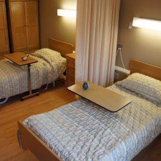 A twin-bedded hospital room featuring a cozy atmosphere with warm lighting.