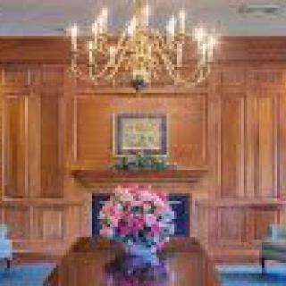 Elegant dining room with chandelier and wood paneling.