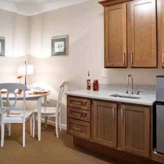 A cozy kitchenette with wooden cabinets and a small dining area.