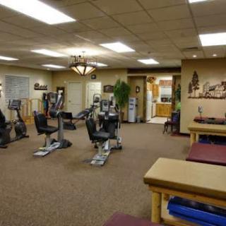 A spacious fitness center equipped with exercise machines and rehabilitation areas.
