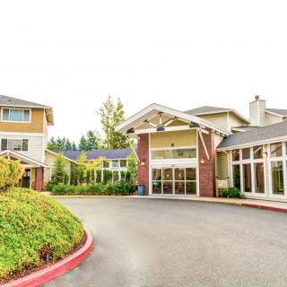 A spacious and welcoming residential building with a landscaped driveway entrance.