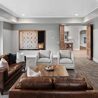 A modern living room with leather sofas, armchairs, and a wooden coffee table.