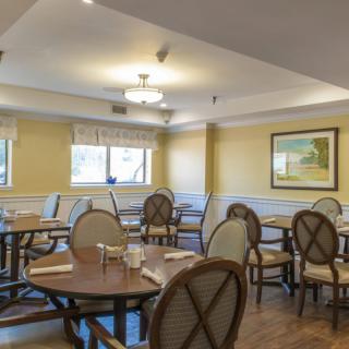 An empty dining room with neatly arranged tables and chairs.