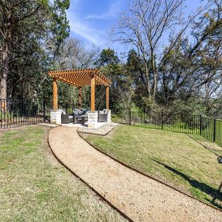 A serene garden with a pergola and a winding pathway surrounded by trees.