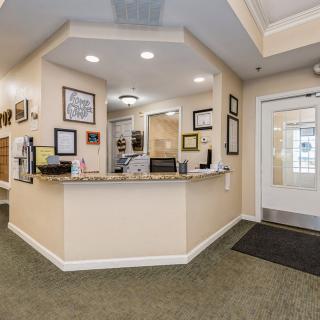 A well-lit reception area with a desk and wall decorations.