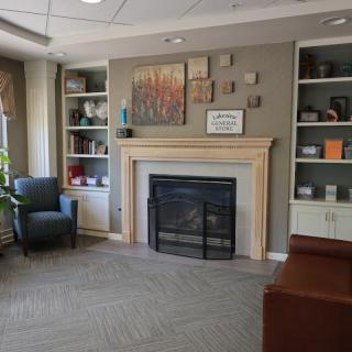 A cozy living room with a fireplace and bookshelves.