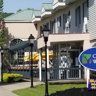 A view of a commercial building with a sign and outdoor seating.
