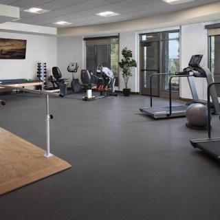 A spacious gym equipped with treadmills, exercise bikes, and dumbbells for a comprehensive workout.