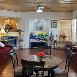 A cozy living room with elegant decor, featuring a comfortable seating area and a central dining table.