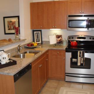 A modern kitchen with wooden cabinetry and stainless steel appliances.
