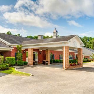A well-maintained building entrance with a driveway and landscaping.