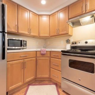 A modern kitchen with wood cabinets and stainless steel appliances.