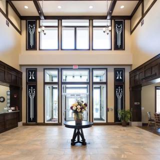 A spacious and elegantly decorated lobby with large windows and a central floral arrangement.