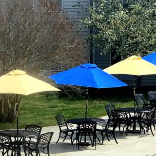 A vibrant outdoor seating area featuring yellow and blue umbrellas next to tables.