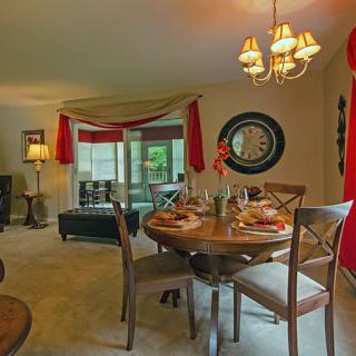 A cozy dining and living area with a round table, chairs, and stylish decorations.
