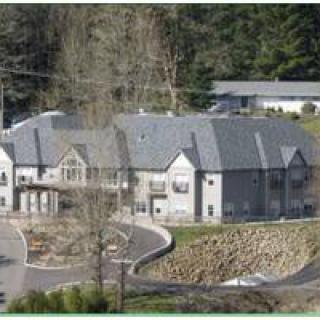A large residential building surrounded by trees.