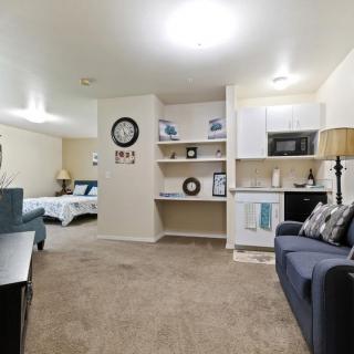 A cozy studio apartment with an open-plan design, featuring a living area, bedroom space, and kitchenette.