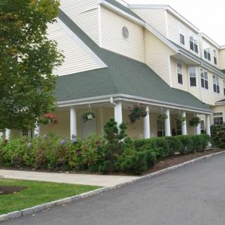 A residential building with a green roof and a well-maintained landscaped entrance.