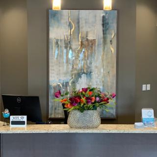 A modern reception area featuring a beautiful floral arrangement and contemporary artwork.