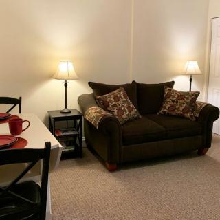 A cozy living room with a sofa, cushions, and warm lighting.