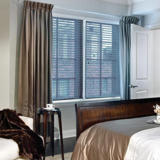 A modern bedroom with sleek window blinds and elegant curtains.