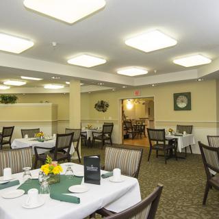 A well-lit dining area with neatly arranged tables and chairs.