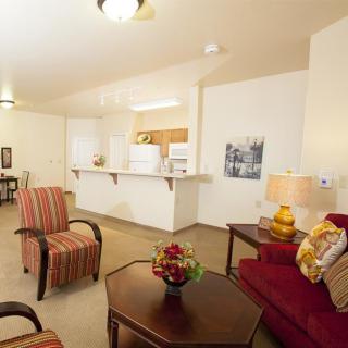 An open-concept living room with comfortable seating and a view of the kitchen.