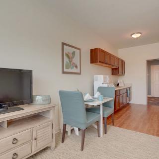A cozy apartment living space featuring a small dining table and kitchen area.