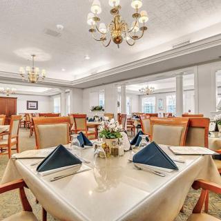 An elegant dining room with neatly arranged tables and chandeliers.