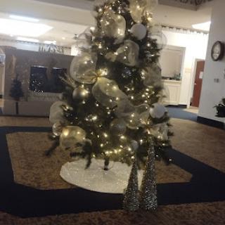 A beautifully decorated Christmas tree with lights and ornaments, set in a cozy indoor space.