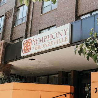 A sign for Symphony at Bronzeville on a brick building.