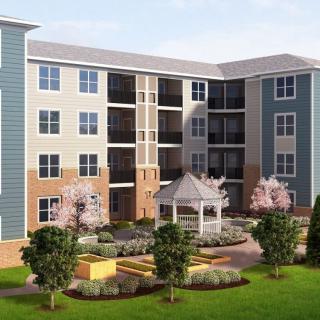 A modern apartment building with landscaped gardens and outdoor seating areas.