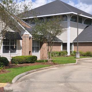 A suburban-style building with landscaped surroundings and a clear sky.