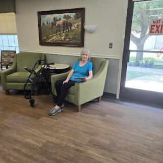 An elderly woman enjoying a moment of relaxation in a community seating area.