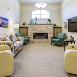 A cozy living room featuring a central fireplace, comfortable seating, and modern decor.