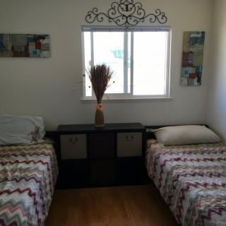 A cozy bedroom with twin beds and decorative elements.