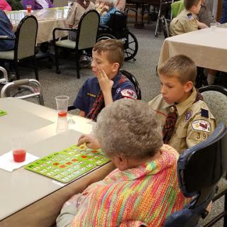 Children participating in a bingo game with elderly individuals at a community event.