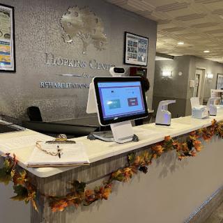 A welcoming reception area adorned with autumn decorations, featuring modern technology at the front desk.
