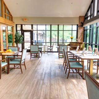 A bright and airy restaurant dining area with modern furniture and large windows.